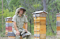 Portrait of Tim Malfroy at an apiary of Warré hives.///Portrait de Tim Malfroy sur un rucher de ruches warré.